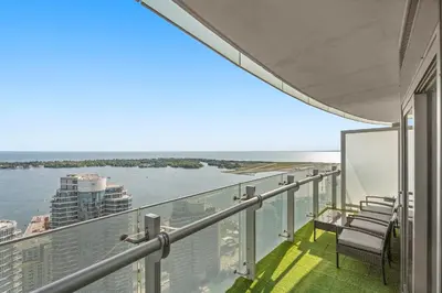 a balcony with chairs and a view of the water at Luxury Lakeview Downtown Condo, CN Tower, Rogers Center, Scotia Arena, Lake View with Free Parking in Toronto