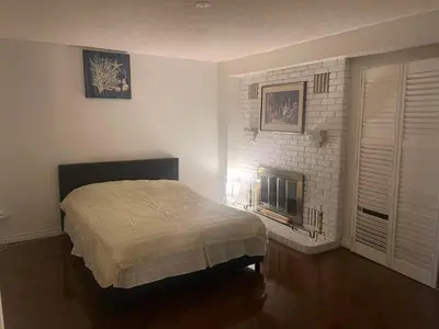 a bedroom with a bed and a fireplace at scarborough home in Toronto