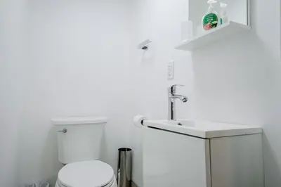 a white bathroom with a toilet and a sink at 2 Bed 2 Bath Bunglow in Mississauga Yyz PortCredit in Mississauga