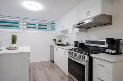 a kitchen with white cabinets and a stove top oven at 2 Bed 2 Bath Bunglow in Mississauga Yyz PortCredit in Mississauga
