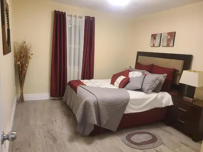 a bedroom with a bed with red curtains at 2 Bedroom house in East-York in Toronto
