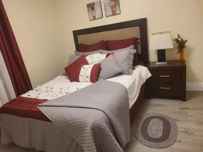 a bedroom with a large bed with red pillows at 2 Bedroom house in East-York in Toronto