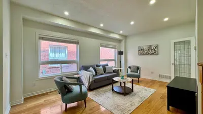 a living room with a couch and two chairs at Spacious 4BD Oasis with Sauna in Mississauga