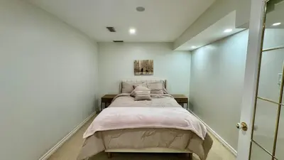 a bedroom with a bed in a white room at Spacious 4BD Oasis with Sauna in Mississauga