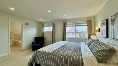 a bedroom with a bed and a large window at Spacious 4BD Oasis with Sauna in Mississauga