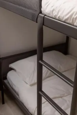 a bunk bed with white sheets and a pillow at Top Graded Metropolitan Suite with Free Parking in Toronto