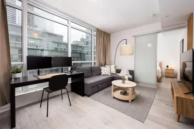 a living room with a couch and a desk at Top Graded Metropolitan Suite with Free Parking in Toronto