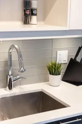a kitchen sink with a faucet and a plant at Top Graded Metropolitan Suite with Free Parking in Toronto