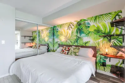 a bedroom with two beds and a mural of leaves at Chic 1BR plus Den Condo with Fast WiFi and Free Parking in Toronto