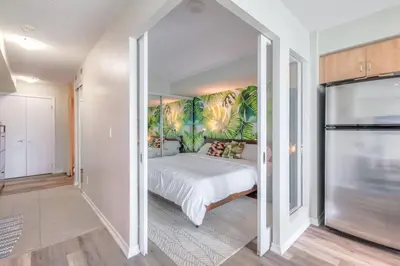 a bedroom with a large bed with a tropical wall at Chic 1BR plus Den Condo with Fast WiFi and Free Parking in Toronto