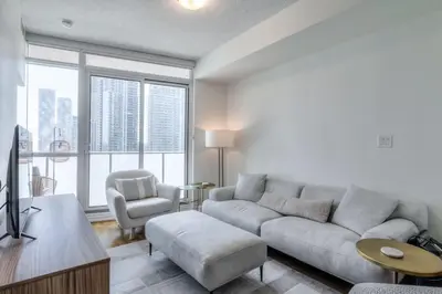 a living room with a couch and a chair at 1BR plus Den Condo with Balcony in Heart of Toronto in Toronto