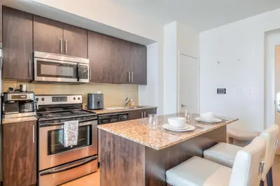 a kitchen with stainless steel appliances and a counter at 1BR plus Den Condo with Balcony in Heart of Toronto in Toronto