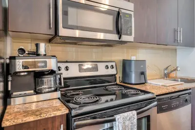 a kitchen with a stove and a microwave at 1BR plus Den Condo with Balcony in Heart of Toronto in Toronto