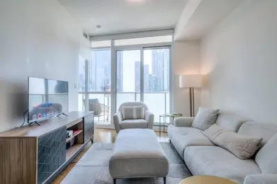 a living room with a couch and a tv at 1BR plus Den Condo with Balcony in Heart of Toronto in Toronto