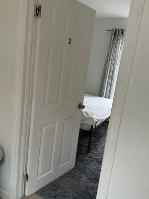 a white door in a room with a bed at Goldwin's Place in Toronto