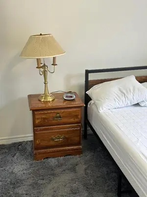 a lamp on a night stand next to a bed at Goldwin's Place in Toronto