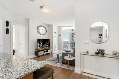 a kitchen and living room with white walls and a table at Lavish 2BR 2Bath Condo Steps to Square One Mall in Mississauga
