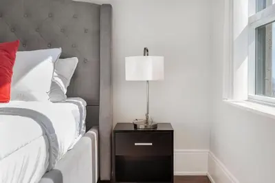 a bedroom with a bed and a lamp on a night stand at Lavish 2BR 2Bath Condo Steps to Square One Mall in Mississauga