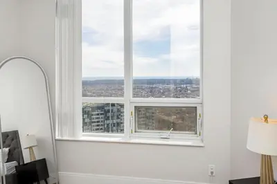 a window in a white room with a view of a city at Lavish 2BR 2Bath Condo Steps to Square One Mall in Mississauga
