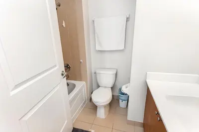 a white bathroom with a toilet and a sink at Lavish 2BR 2Bath Condo Steps to Square One Mall in Mississauga