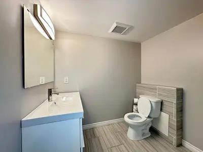 a bathroom with a white toilet and a sink at Mountain View House - Sleeps 14 in St. Catharines