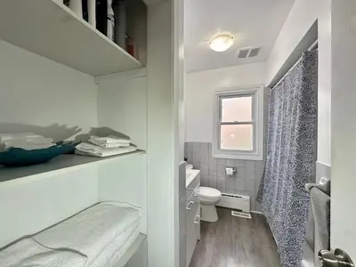 a small white bathroom with a toilet and a window at Mountain View House - Sleeps 14 in St. Catharines