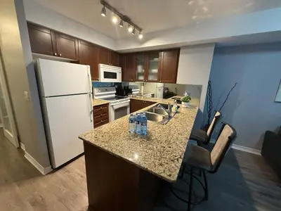 a kitchen with a white refrigerator and a counter at Large Downtown 2Br condo with Parking steps to Eaton Centre, UofT and SickKids in Toronto