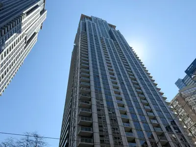 a tall building in the middle of two buildings at Large Downtown 2Br condo with Parking steps to Eaton Centre, UofT and SickKids in Toronto
