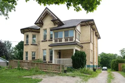 a large brick house with a gambrel roof at Comic House with Climbing Wall & Themes in Chesley