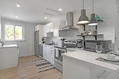 a kitchen with stainless steel appliances and white cabinets at The Dove Loft Near DT & Hospital in Peterborough