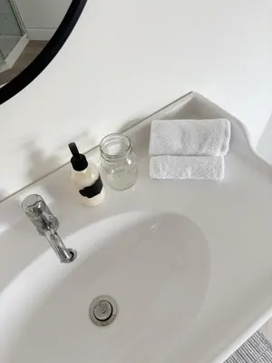 a white bathroom sink with a soap dispenser and towels at The Dove Loft Near DT & Hospital in Peterborough