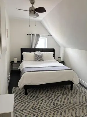 a bedroom with a bed and a ceiling fan at The Dove Loft Near DT & Hospital in Peterborough