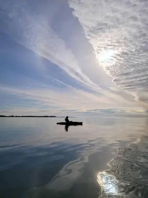 a person sitting on a boat in the water at 5 o clock somewhere in Hamilton