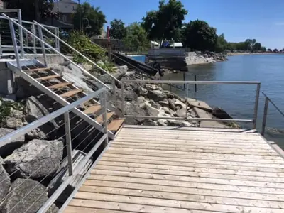 a wooden walkway next to a body of water at 5 o clock somewhere in Hamilton