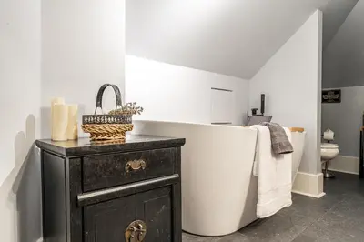 a bathroom with a bath tub and a sink at Glyn Rhosyn Balcony Riverview in Stratford