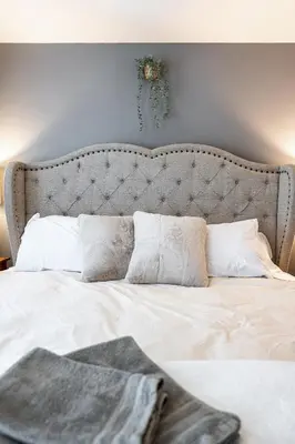 a bedroom with a large bed with white sheets and pillows at Glyn Rhosyn Balcony Riverview in Stratford