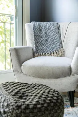 a living room with a chair with a pillow on it at Glyn Rhosyn Balcony Riverview in Stratford