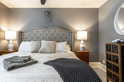 a bedroom with a bed with a blanket and two lamps at Glyn Rhosyn Balcony Riverview in Stratford