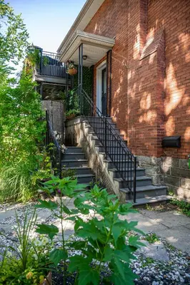 a brick house with stairs leading to a door at Glyn Rhosyn Balcony Riverview in Stratford
