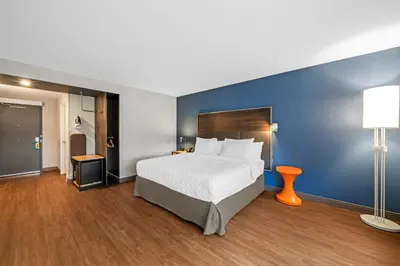 a hotel room with a bed and a blue wall at Tru By Hilton Oshawa in Oshawa
