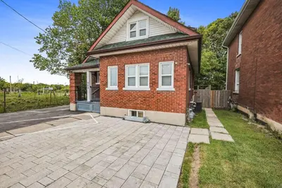 a brick house with a driveway in front of it at Comfy 2BR Apt near Beach and Downtown Free Parking in Oshawa