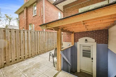 a patio with a wooden pergola next to a building at Comfy 2BR Apt near Beach and Downtown Free Parking in Oshawa