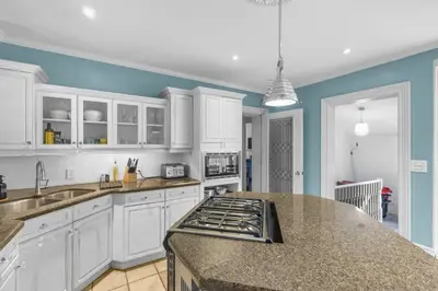 a kitchen with white cabinets and a counter top at Mins to Beach Downtown 5BR w Pool Patio and BBQ in Cobourg