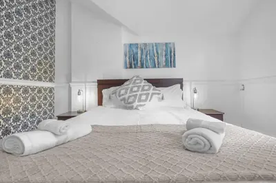 a bedroom with a large bed with towels on it at Mins to Beach Downtown 5BR w Pool Patio and BBQ in Cobourg