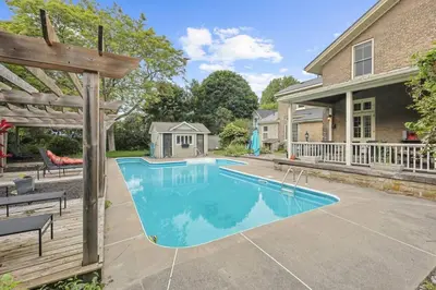 a swimming pool in front of a house at Mins to Beach Downtown 5BR w Pool Patio and BBQ in Cobourg