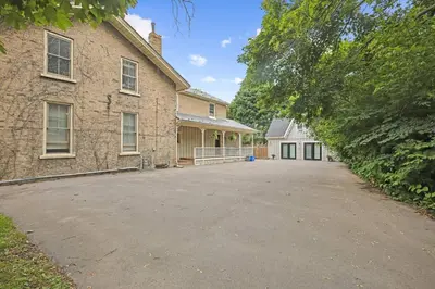 an empty driveway in front of a brick building at Mins to Beach Downtown 5BR w Pool Patio and BBQ in Cobourg