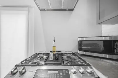 a kitchen with a stove and a microwave at 2BR Downtown Retreat Mins to Beach BBQ and Firepit in Cobourg