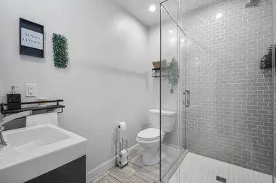 a bathroom with a toilet and a glass shower at 2BR Downtown Retreat Mins to Beach BBQ and Firepit in Cobourg