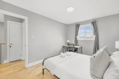 a white bedroom with a bed and a window at 3BR Pickering Retreat with BBQ and Patio Delight in Pickering