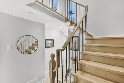 a stairway with a circular mirror and wooden stairs at 3BR Pickering Retreat with BBQ and Patio Delight in Pickering